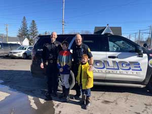 two police officers posing with two boys