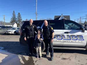 Police officers posing with two students
