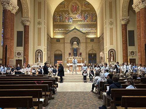 Students participating in a beautiful living rosary in the church sanctuary