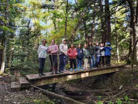 Students standing on a wooden bridge