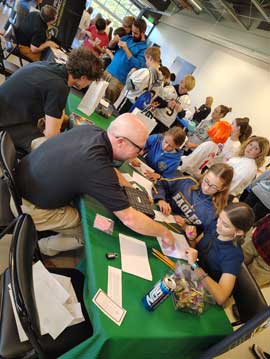 An adult explaining a paper to students