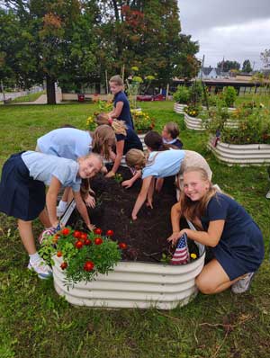 Smiling students digging in the soil