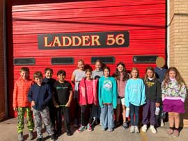 Students under a sign that reads Ladder 56