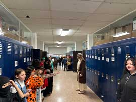Students and staff dressed for Halloween lining the hallway
