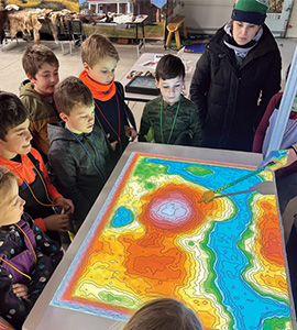 Students and adults looking at a map