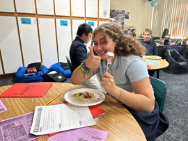 Student eating potatoes with thumb up