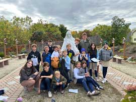 Group photo of students around a statue