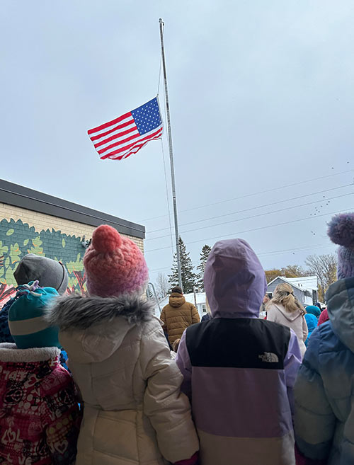 Crowd looking at the raised American flag