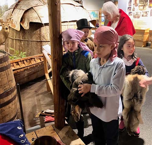 student in costume holding animal pelt