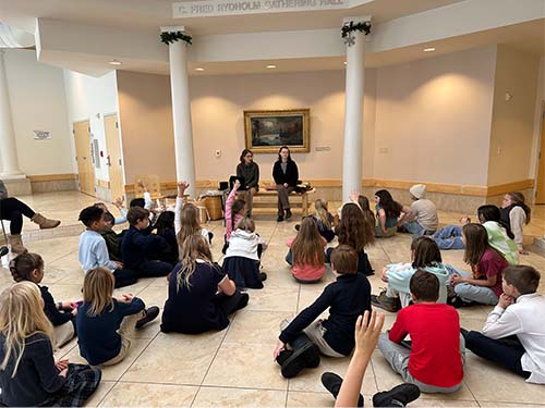 Students gathered on the floor listening