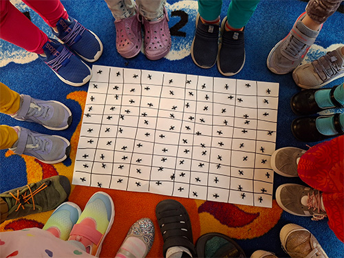 Students standing around a poster of ants