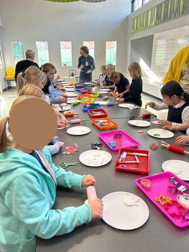 Second grade students sitting at a craft table during their field trip to the local library