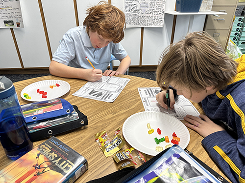 Students enjoying an activity using gummy bears to learn about forms of government