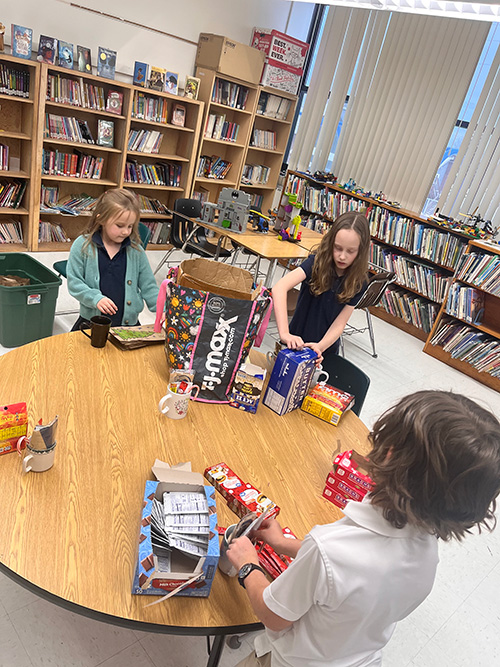 Students around a table working on coffee mug service project