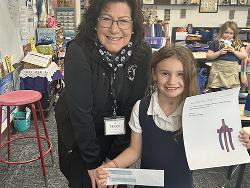 Mrs. Tavernini with a happy student holding the donation check