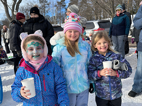Three happy girls outside in winter apparel