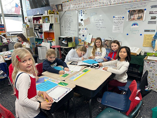 Group of happy students working together in the classroom
