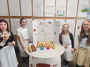 Four fifth grade girls dressed as colonial bakers
