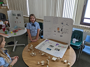 Fifth grade girls presenting fancy furniture from colonial times
