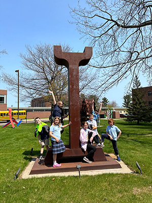 Father Marquette students surrounding sculpture outside DeVos Art Museum