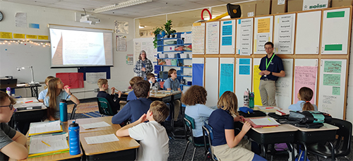 Student listening to Seminarian speak in front of classroom