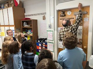 Deacon Gregg blessing third grade classroom