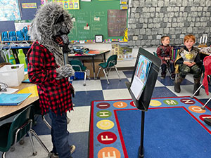 Student dressed as a werewolf reading for the class