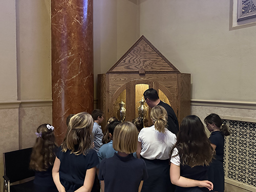 Father Tim teaching students about the sacristy, vestments, sacred oils, and the liturgy of the word