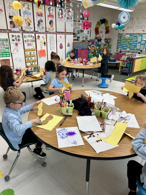 Kindergarten students enjoying Mardi Gras arts and crafts