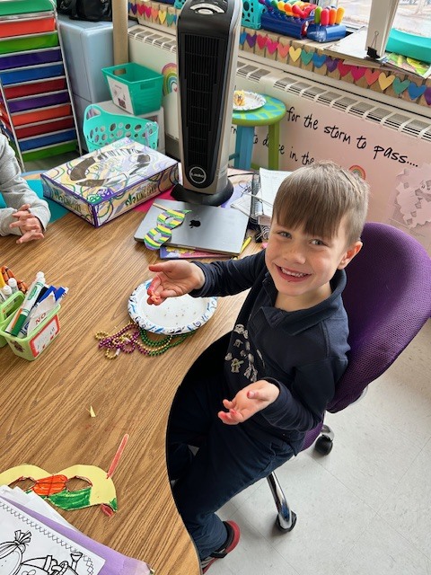 Kindergarten students holding up beads