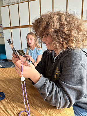 Student holding her prayer card at her desk