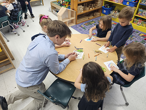 Students coloring at a round table