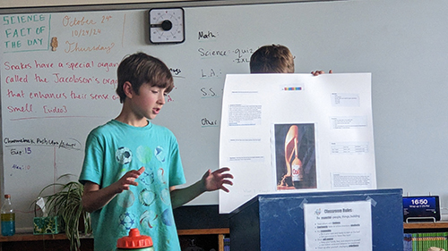 Student presenting his science project next to a podium