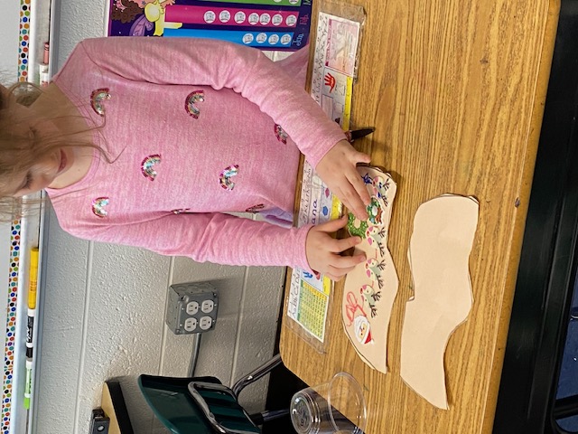 First grader making a wooden shoe at her desk