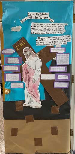classroom door decorated with Jesus next to cross that says INRI and a heading that says Seventh Station Jesus Falls The Second Time and other words to small to read