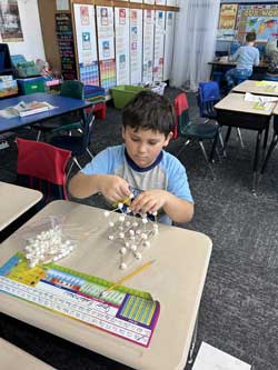 student building marshmallow and toothpick design