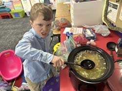 Boy snarling as he stirs soup in a crockpot
