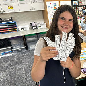 A student holding up a paper hand