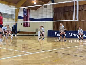 Volleyball team playing game in gym