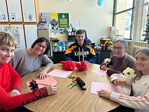 staff and students sitting at a table