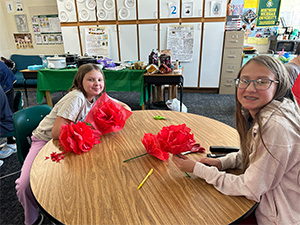 two female students sitting at a table