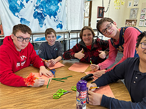 5 male students sitting at a table together